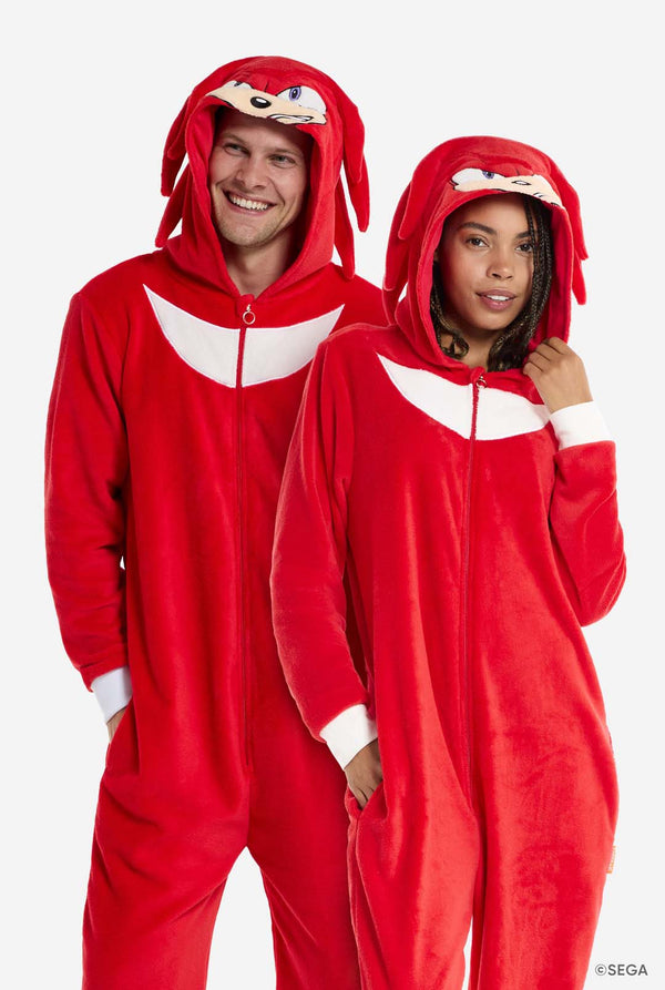 Two people wearing red Knuckles-themed onesies on a white background