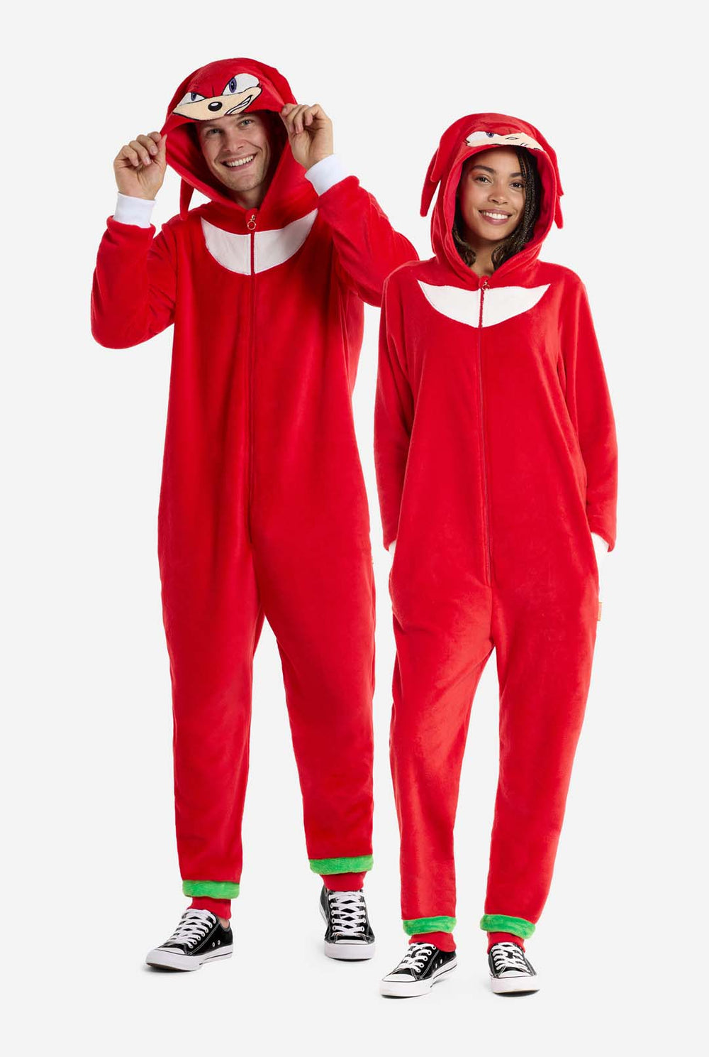 Two people wearing red Knuckles-themed onesies on a white background