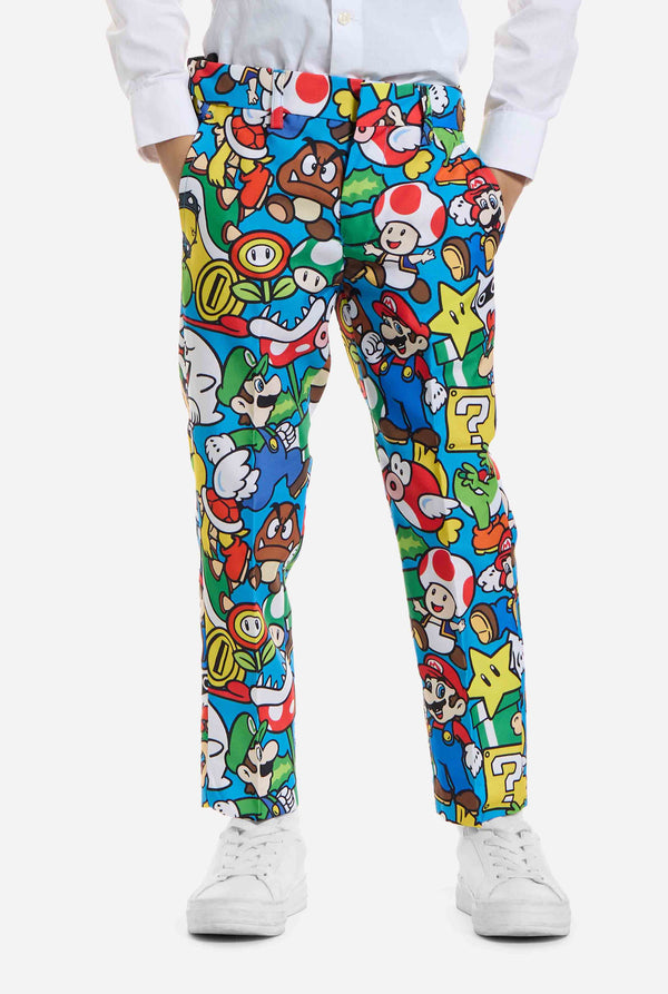 Image of kid wearing a Super Mario all over print suit, consisting of blazer, pants and tie. Main color is blue, but there is also yellow, red and white. View of the pants.