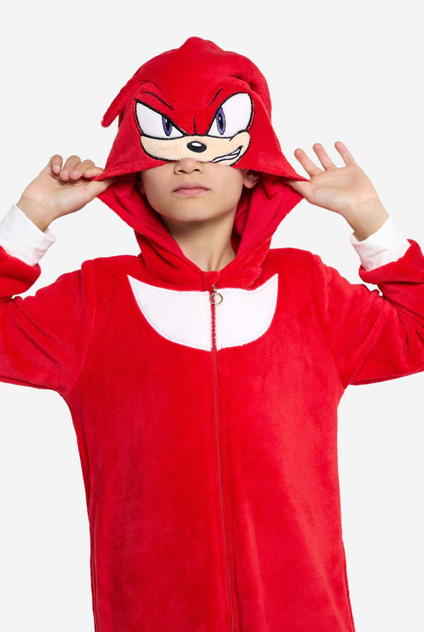 Person wearing a red Knuckles onesie with a hood and face design on a white background
