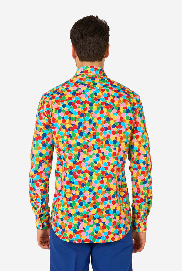 Man wearing a colorful polka dot confetti shirt on a white background, view from the back.