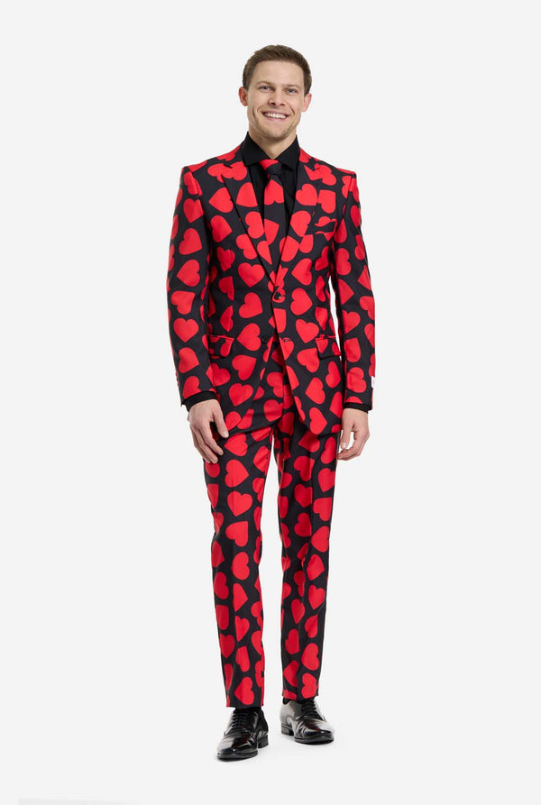 Man wearing a red heart-patterned suit on a white background, full body image