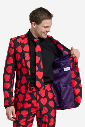 Man wearing a red heart patterned suit with a purple inside on a white background