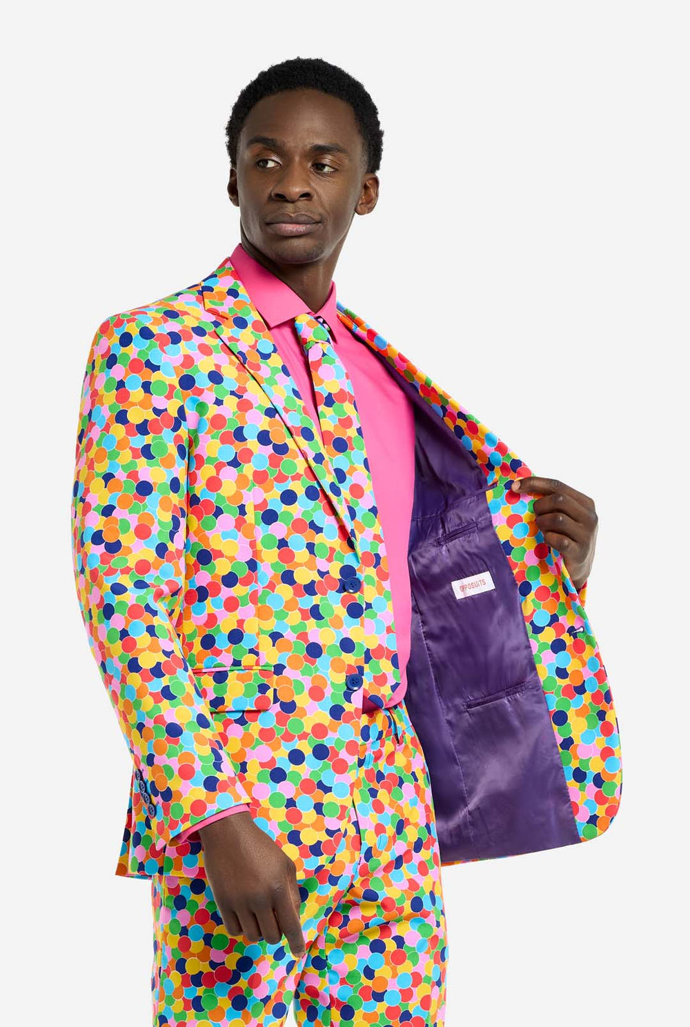Video of man wearing Confetteroni men's suit with all over confetti print, showing suit like a model. Suit consists of blazer, pant and tie.
