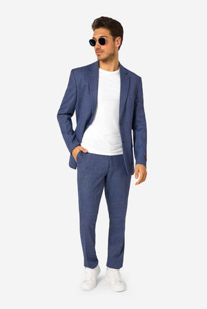 Man wearing a blue checkered suit with white shirt and sneakers on a white background