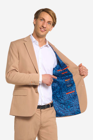 Man wearing a beige suit with a blue inner lining, pointing to the inner lining.