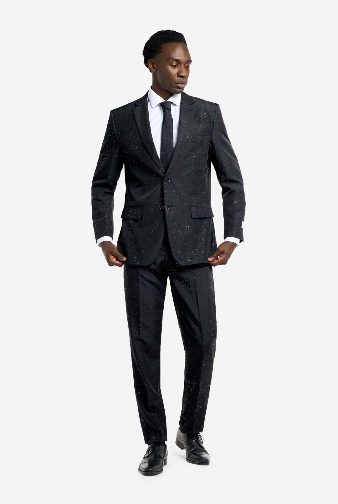 Image of a man wearing an OppoSuits Glitzy Glitter men's suit with glitters and white men's shirt. Suit consist of pants, jacket and tie. Full body image.