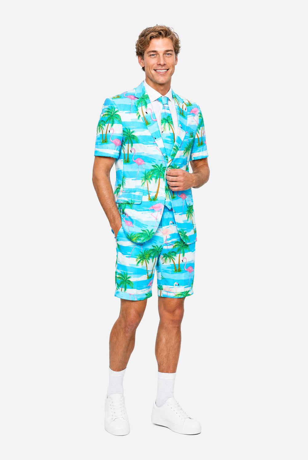 Man wearing a colorful tropical-themed suit, with palm trees and pink flamingos on a light background.