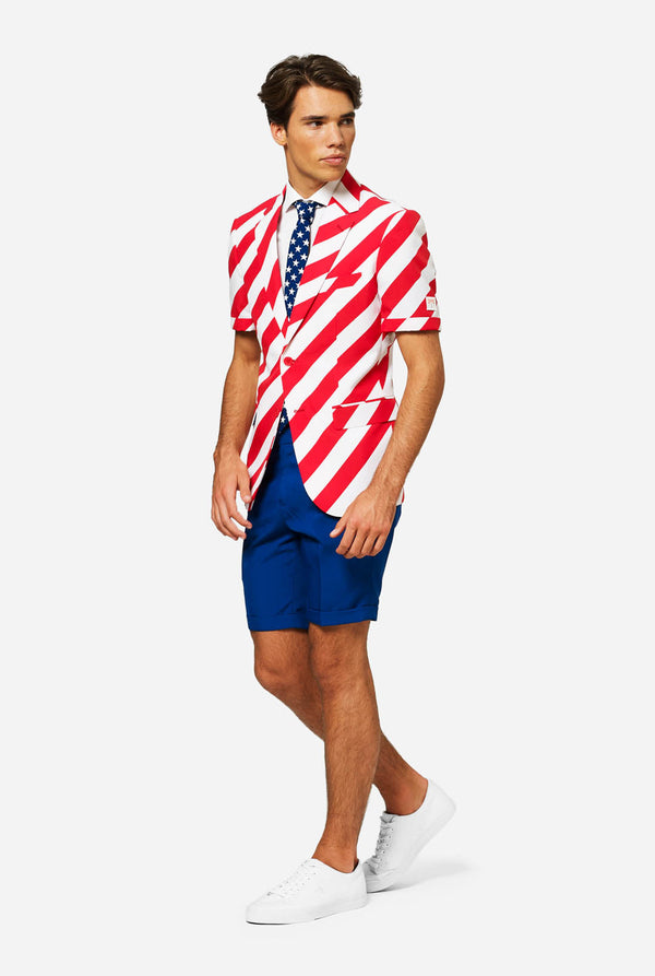 Man wearing a red, white-striped blazer and blue shorts. Resembling an American flag pattern on a plain background. Full body image.
