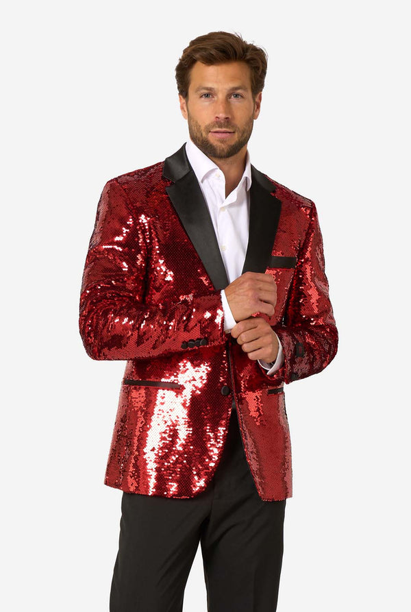 Man wearing a red sequin jacket with black lapels on a white background