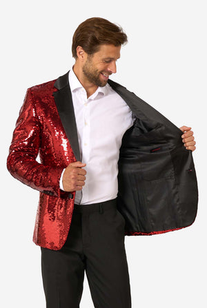 Man holding a red sequin jacket open to reveal a black interior lining.