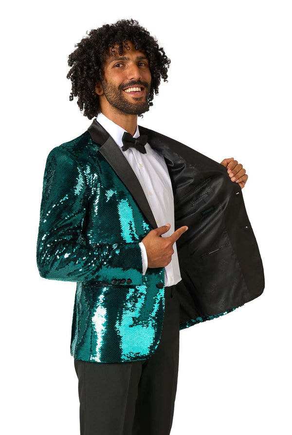Man wearing a teal sequin jacket with a black lapel on a white background