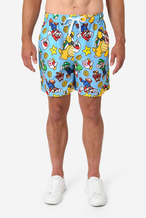 Person wearing colorful Mario-patterned shorts on a white background