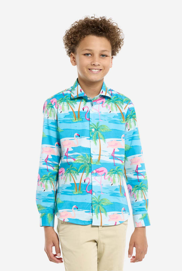 Child wearing a colorful shirt with flamingo and palm tree pattern on a white background