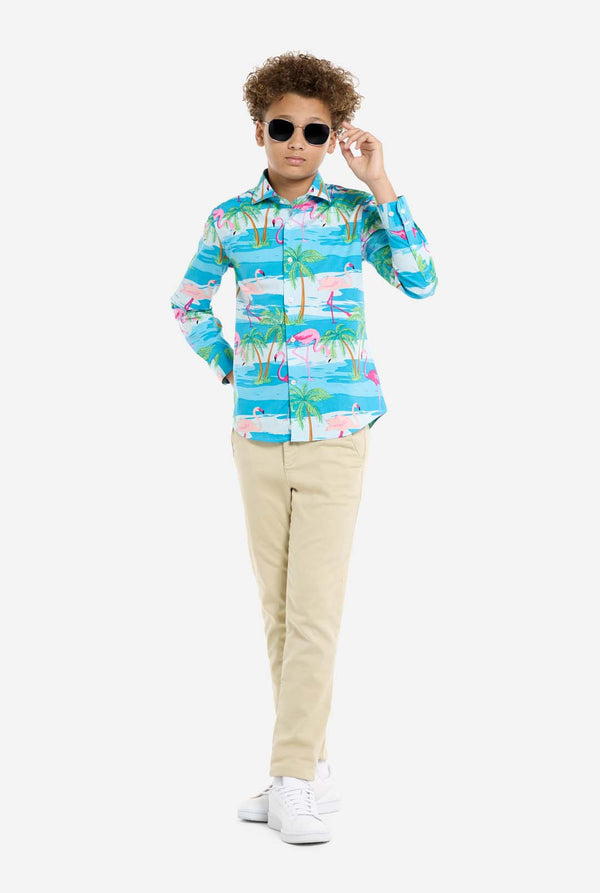 Child wearing a colorful shirt with palm tree design and sunglasses on a white background, full body image