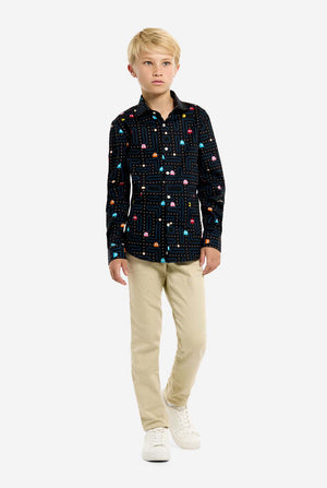 Young boy wearing a black shirt with colorful Pac-Man pattern on a white background, full body image