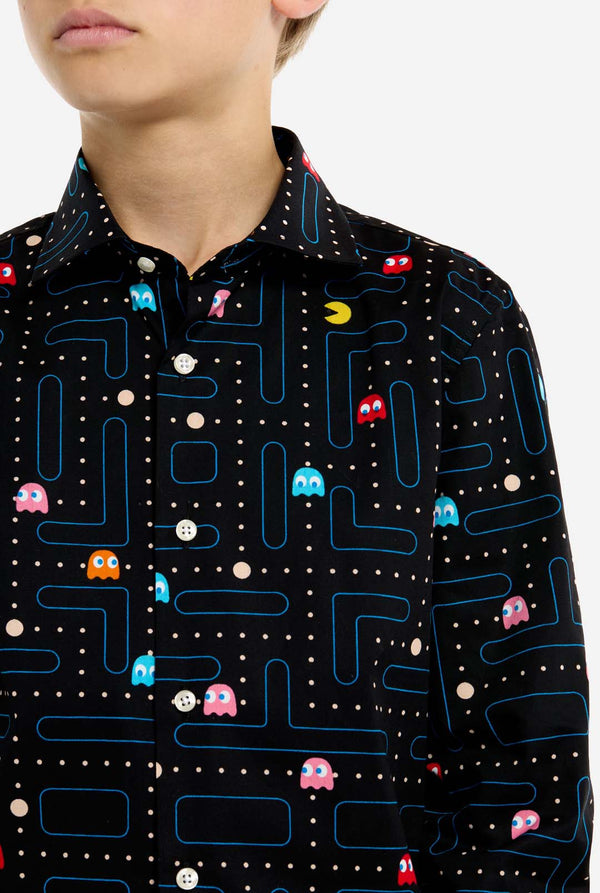 Person wearing a black shirt with colorful Pac-Man game pattern, close up