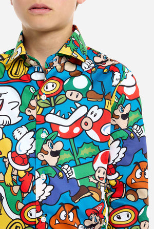 Image of teen wearing a Super Mario all over print shirt. Main color is blue, but there is also yellow, red and white. Chest close up.