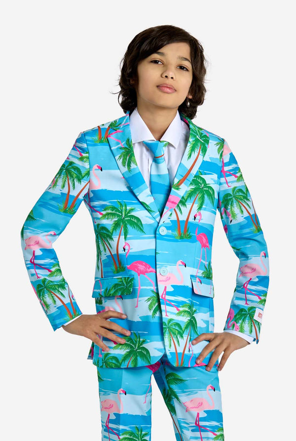 Child wearing a colorful tropical-themed suit with palm trees and flamingos on a white background