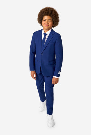 Kid wearing a blue suit with a white shirt and white shoes on a white background