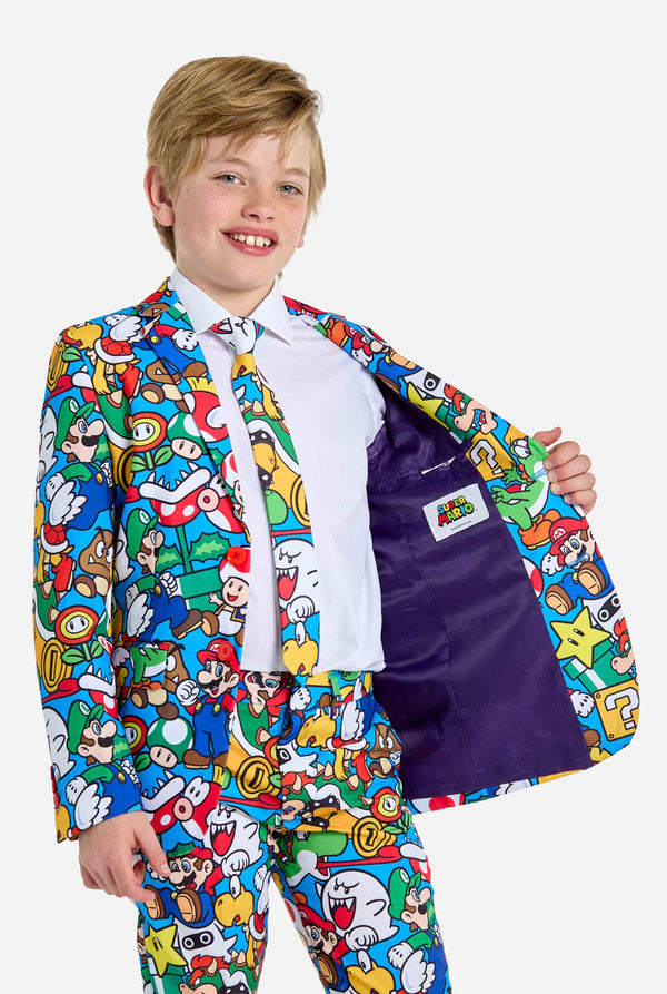 Image of teen wearing a Super Mario all over print shirt, consisting of blazer, pants and tie. Main color is blue, but there is also yellow, red and white. Showing inside of the jacket.