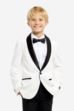 Person wearing a white tuxedo with black bow tie and pants on a white background. Hands in the pockets.