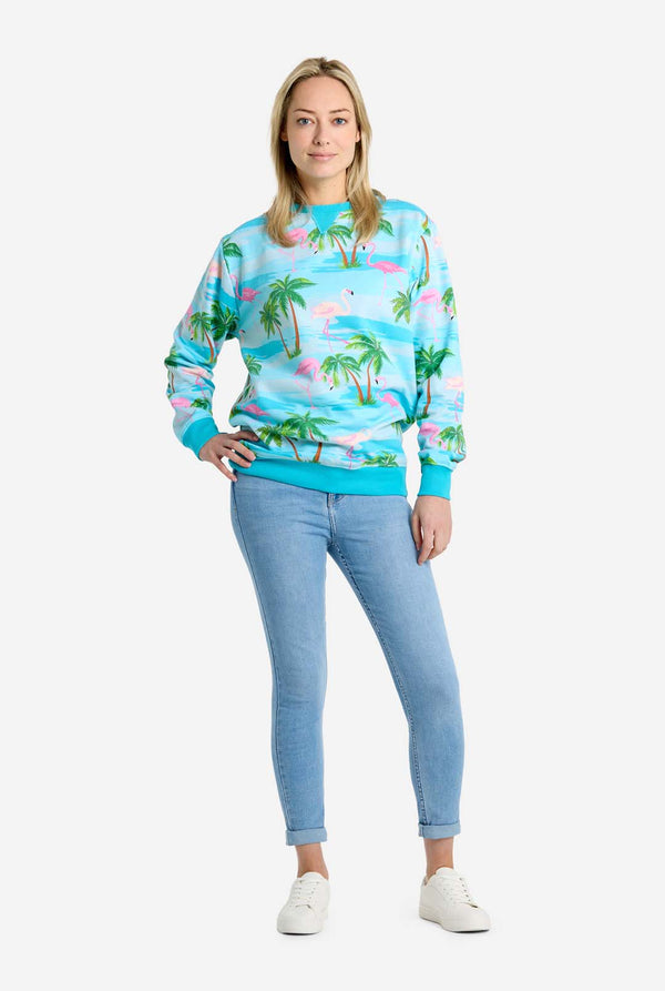 Person wearing a colorful tropical-themed sweatshirt and light blue jeans on a white background