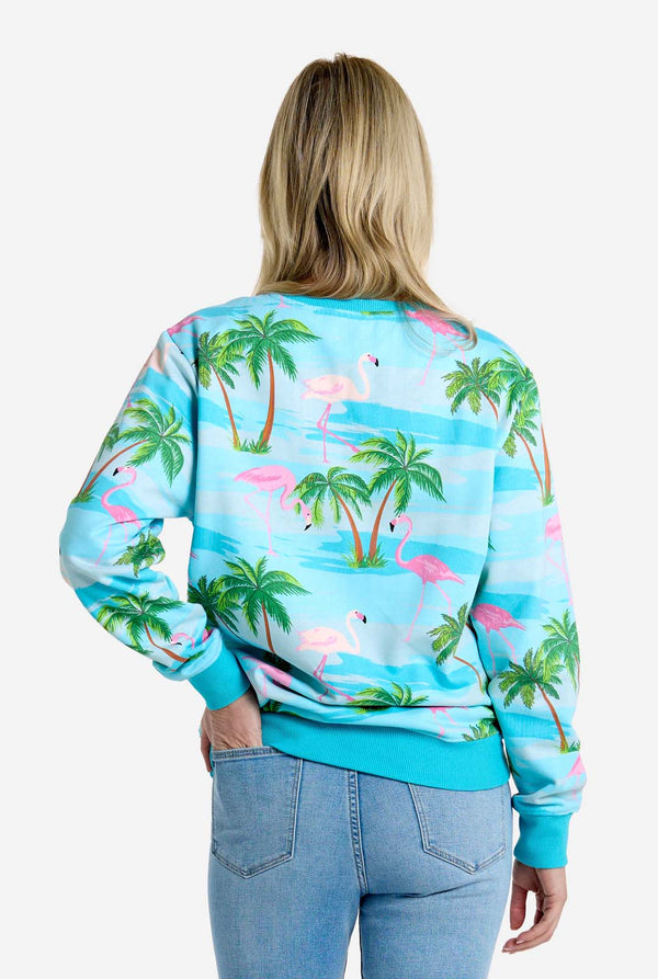 Person wearing a tropical-themed sweatshirt with flamingos and palm trees on a white background, view from the back