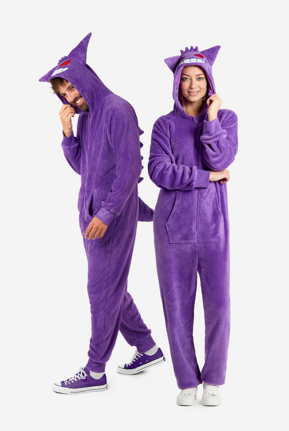 Man and woman wearing purple unisex adult onesie Pokeomon Gengar themed. Both looking at the floor.