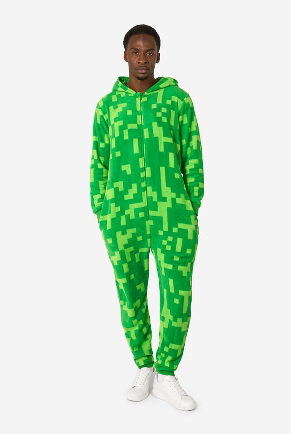 Person wearing a green pixelated Creeper onesie on a white background