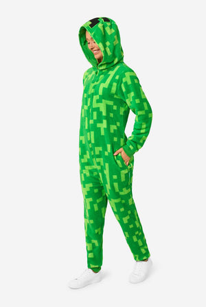 Person wearing a green pixelated Creeper onesie on a white background
