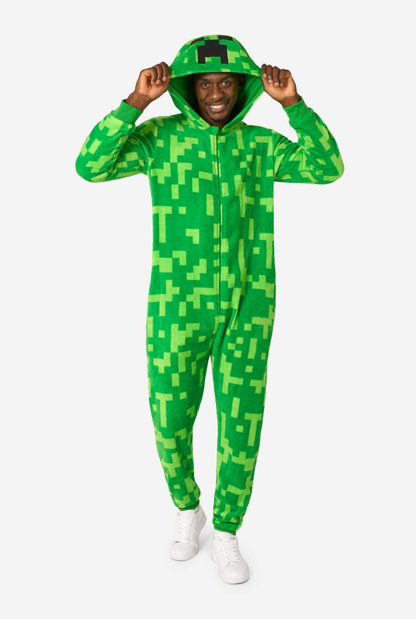 Person wearing a green pixelated Creeper onesie on a white background