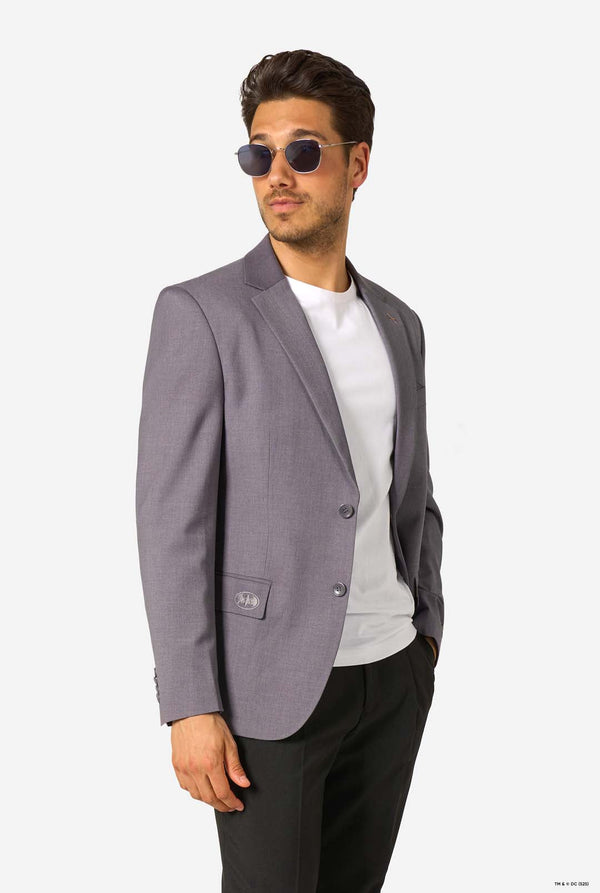 Man wearing a gray blazer, white shirt, and sunglasses on a white background