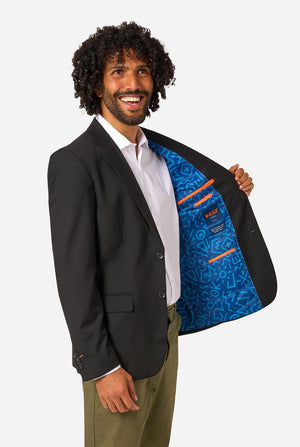 Man wearing a black blazer with a blue inner lining, standing against a white background