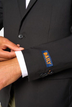 Close-up of a black suit jacket with a visible DAILY label on the sleeve.