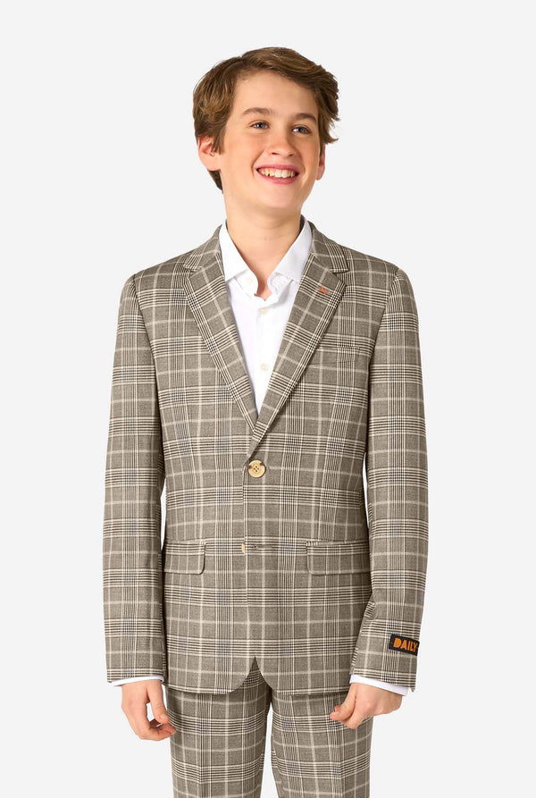 Young boy wearing a tan checkered suit with a white shirt on a white background