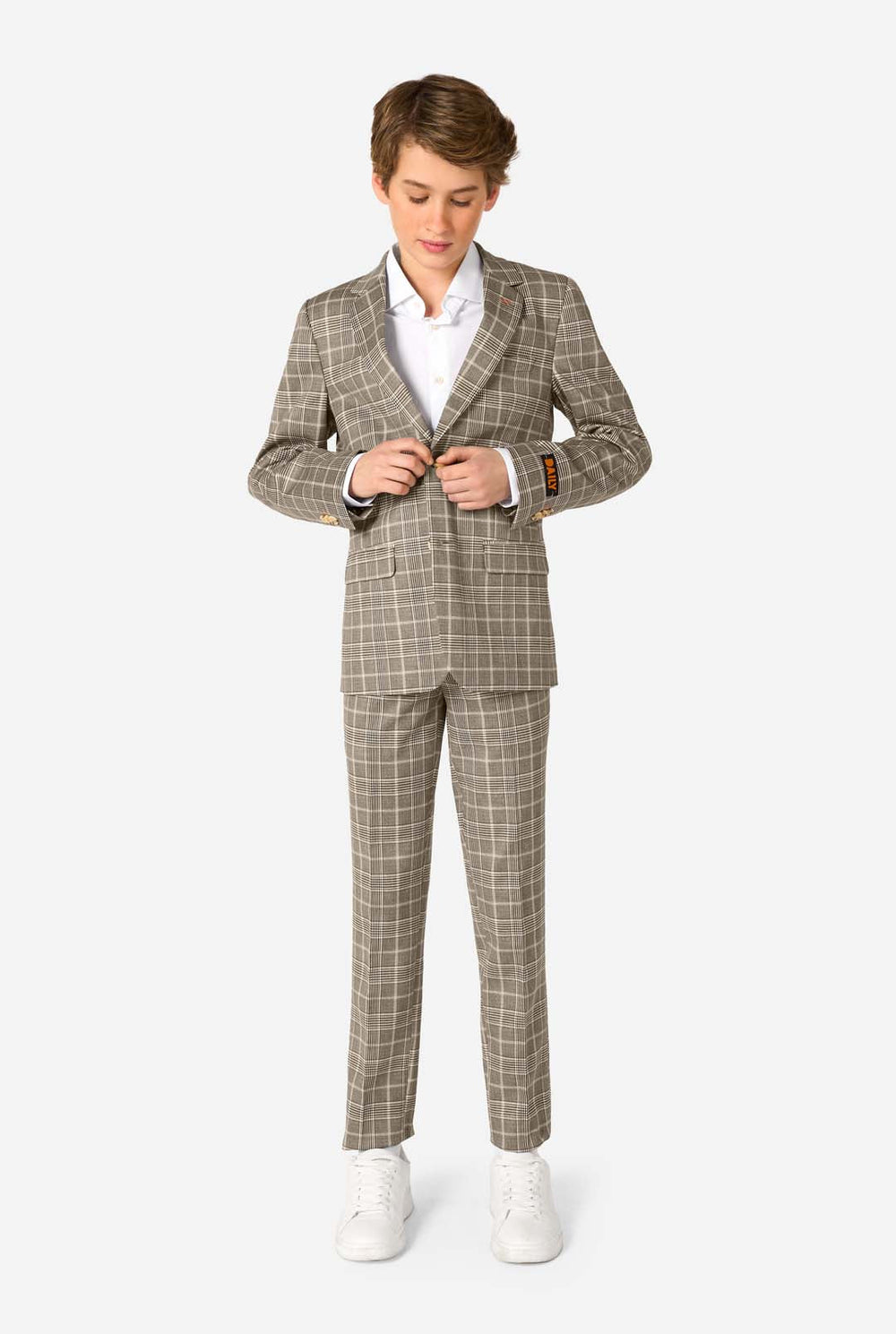 Young boy wearing a tan checkered suit with a white shirt on a white background