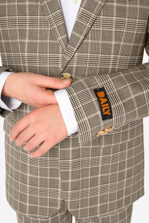 Close-up of a person wearing a tan checkered suit with a Daily label on the sleeve.