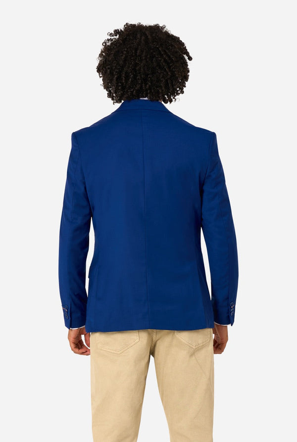 Person wearing a blue blazer and beige pants on a white background. View from the back
