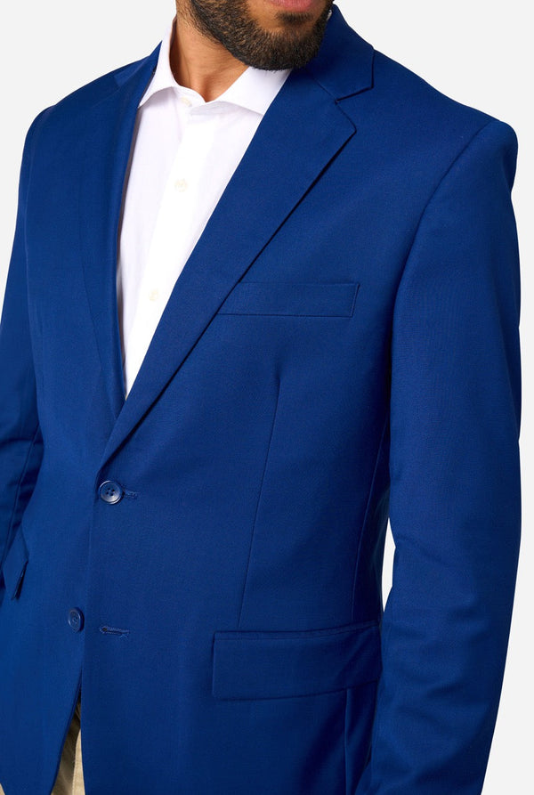 Blue suit jacket worn by a person on a white background. Close up of the chest