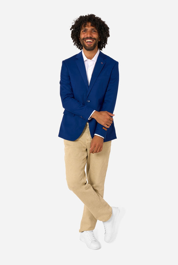Man wearing a blue blazer, white shirt, beige pants, and white shoes on a white background. Full body image
