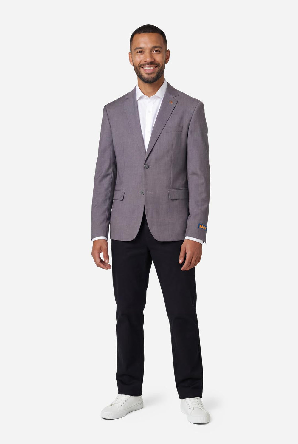 Man wearing a gray blazer over a white shirt on a white background