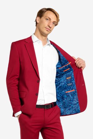 Man wearing a red suit with a blue patterned inner lining, standing against a white background.