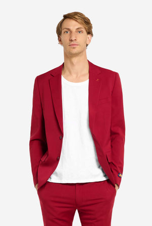 Man wearing a red blazer and pants with a white shirt on a white background