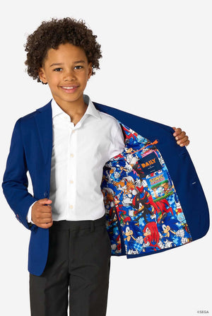 Kid wearing a blue Sonic-themed blazer with a white shirt and dark pants on a light gray background. Holding one side of his jacket open.