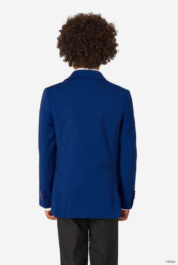 Kid wearing a blue Sonic-themed blazer with a white shirt and dark pants on a light gray background. View from the back.