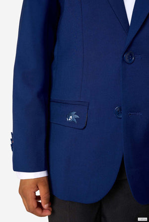 Kid wearing a blue Sonic-themed blazer with a white shirt and dark pants on a light gray background. Close up of the pocket.