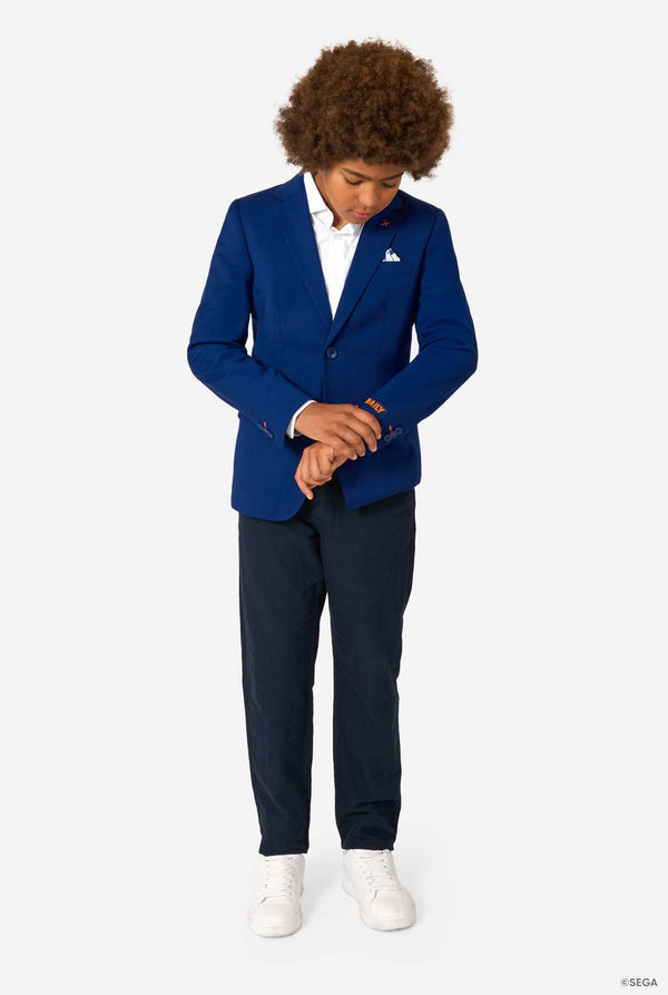 Person wearing a blue blazer and navy pants on a white background. Full body image