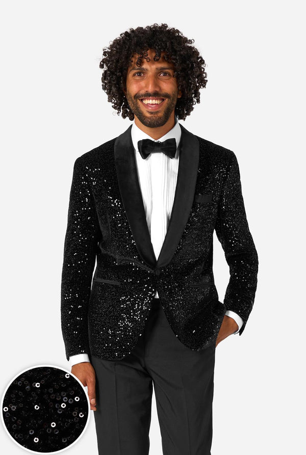 Man wearing a black sequin jacket with a white shirt and bow tie on a white background.