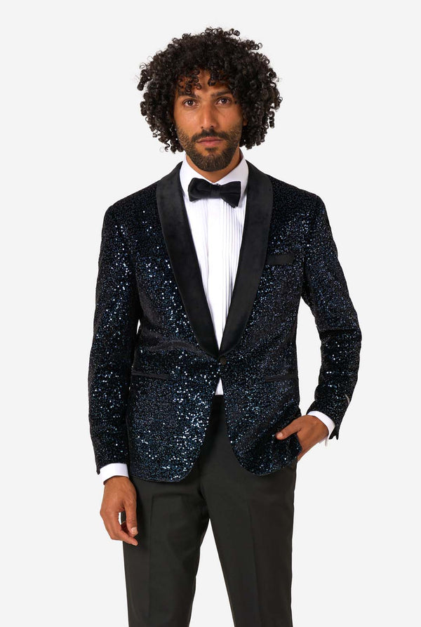 Man wearing a navy sequin tuxedo jacket on a white background